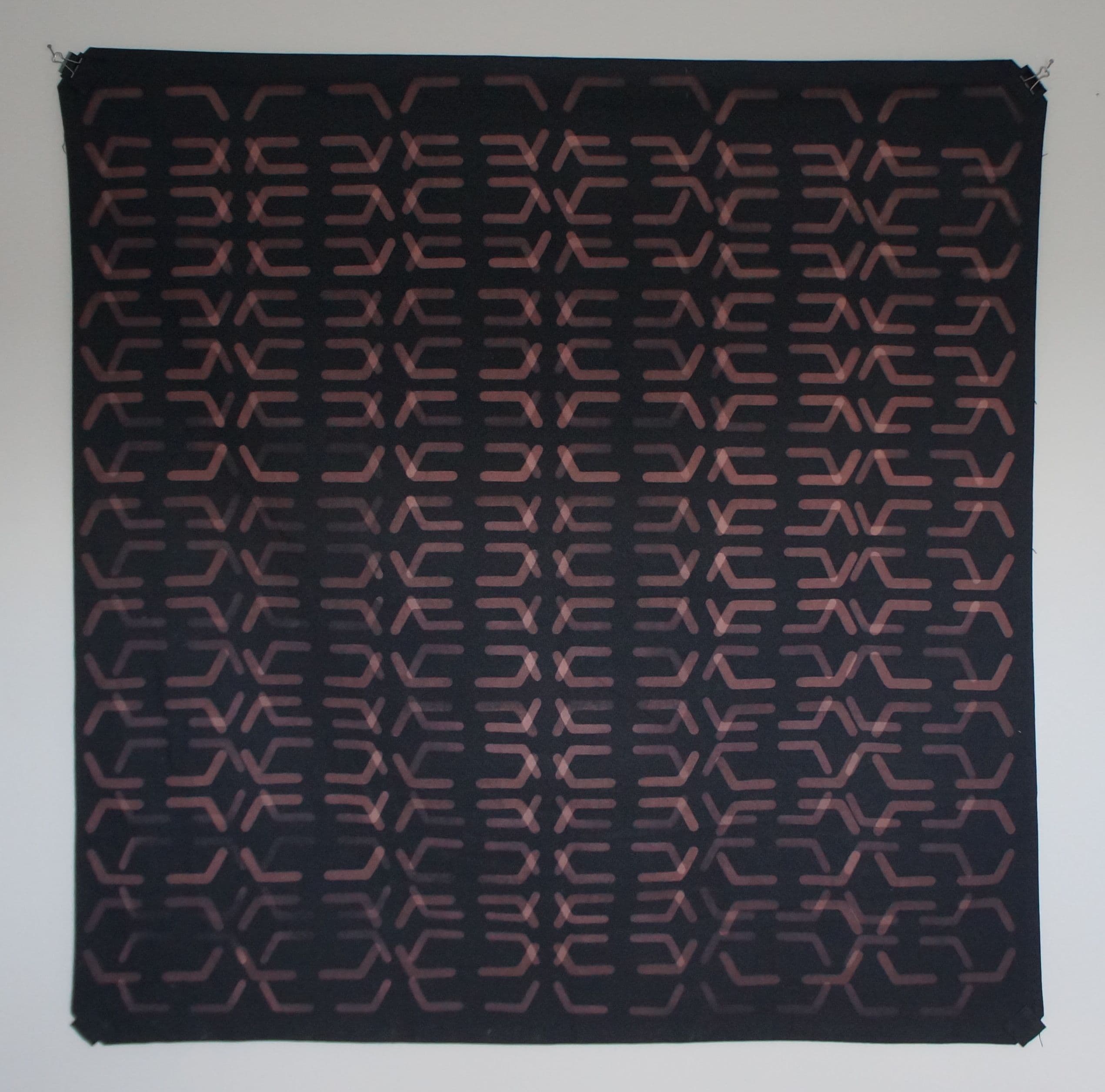 a square canvas piece with grommets in each corner. lines create a shifting pattern