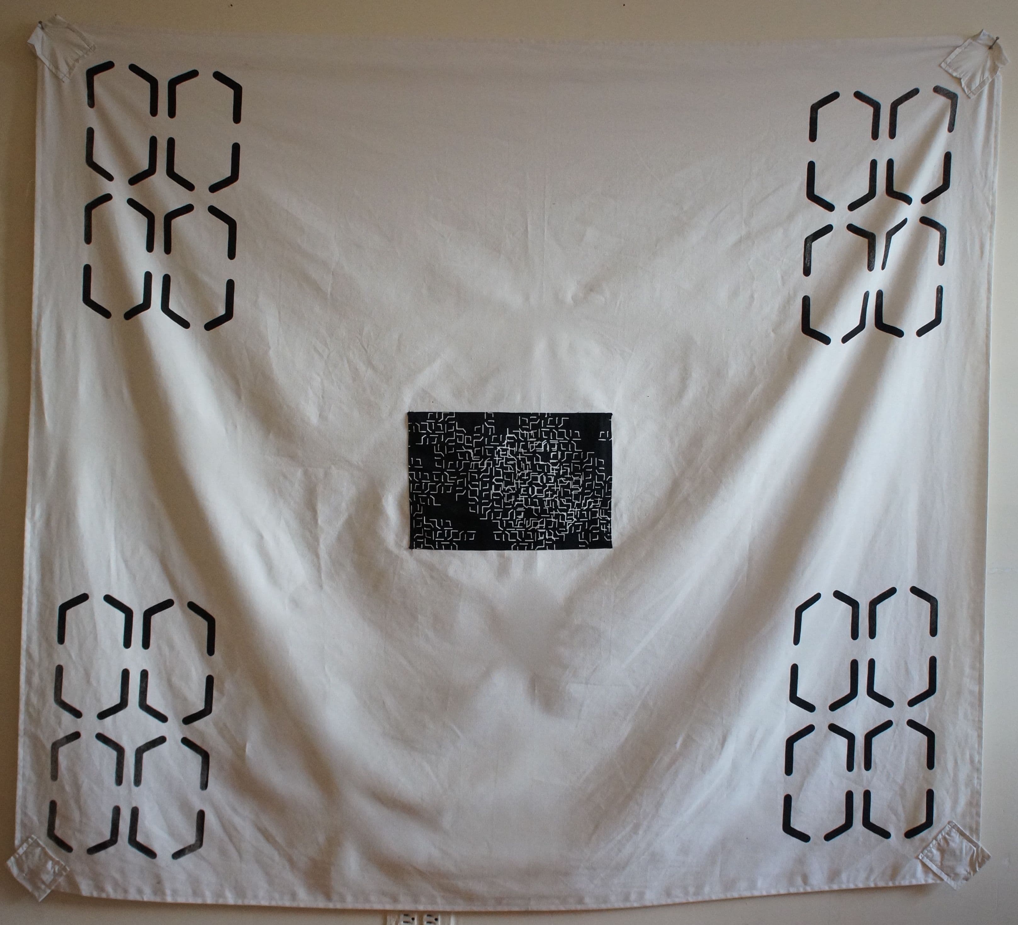 a square canvas piece with grommets in each corner. lines create a shifting pattern